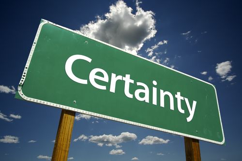 Green road sign with the word Certainty
