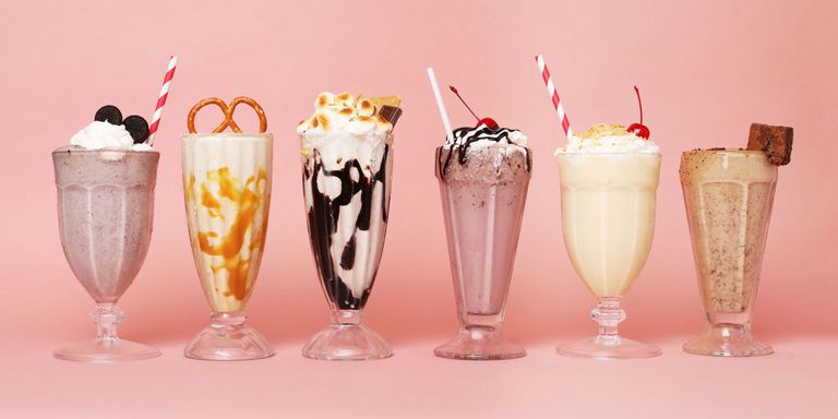 Six glasses of different flavors of milkshake