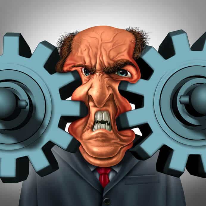 Businessman's face squeezed by two gears