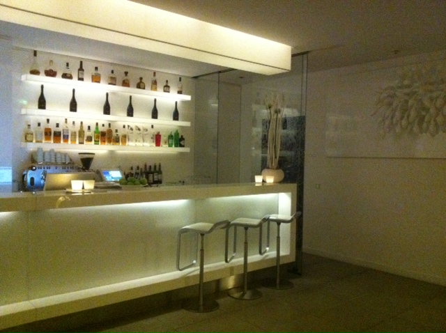 White hotel bar with stools and liquors